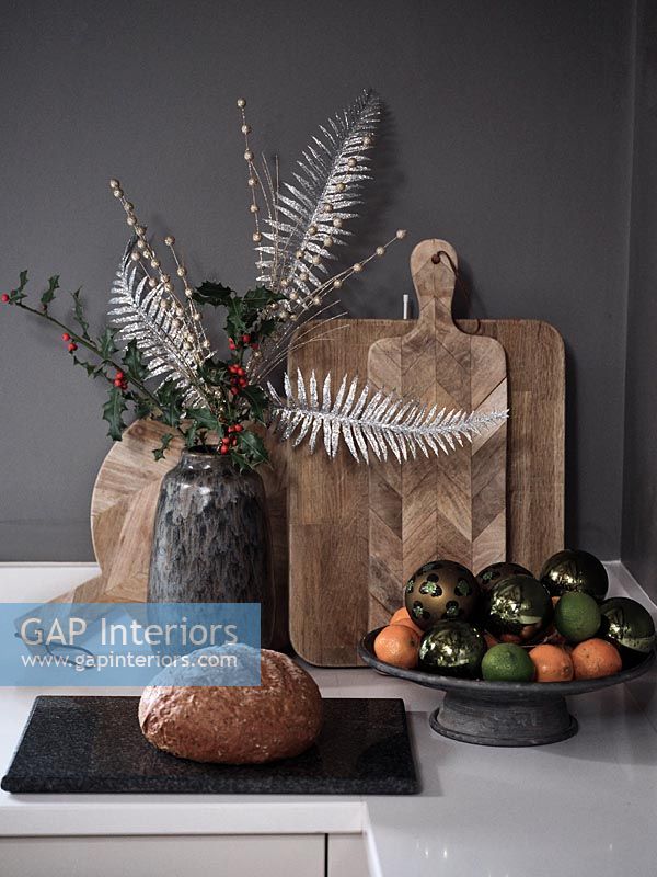 Decorative Christmas arrangement in vase on kitchen worktop 
