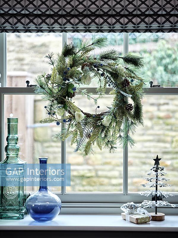 Detail of Christmas wreath hanging by window 