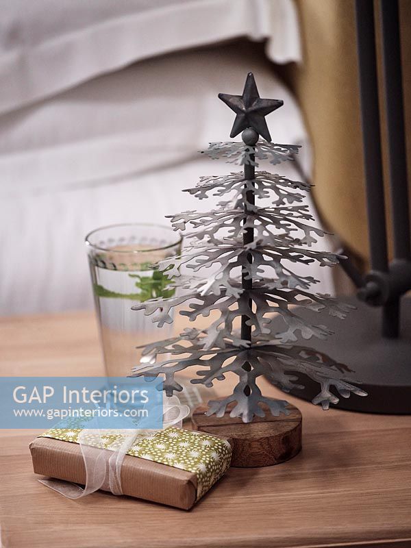 Miniature Christmas tree and gift on bedside table 