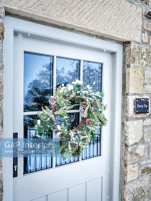 Christmas wreath on front door of country house 