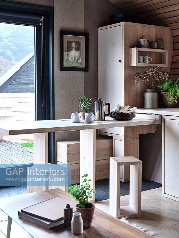 Modern wooden kitchen with pull out breakfast bar and stools 