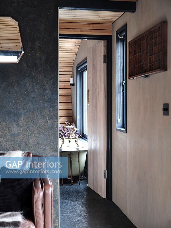 View into modern bathroom through open internal wooden doors 