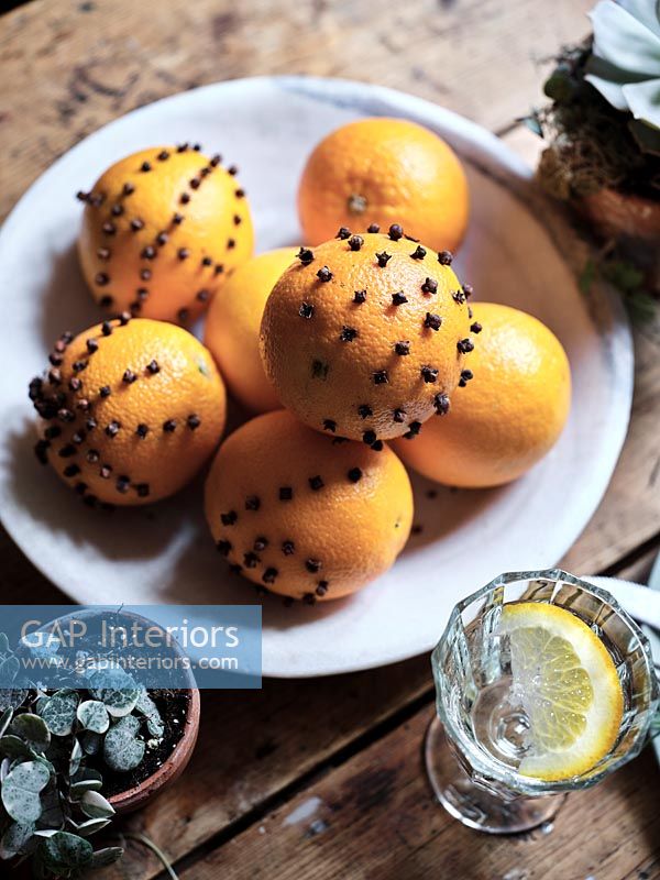 Orange and clove pomanders on table - detail 