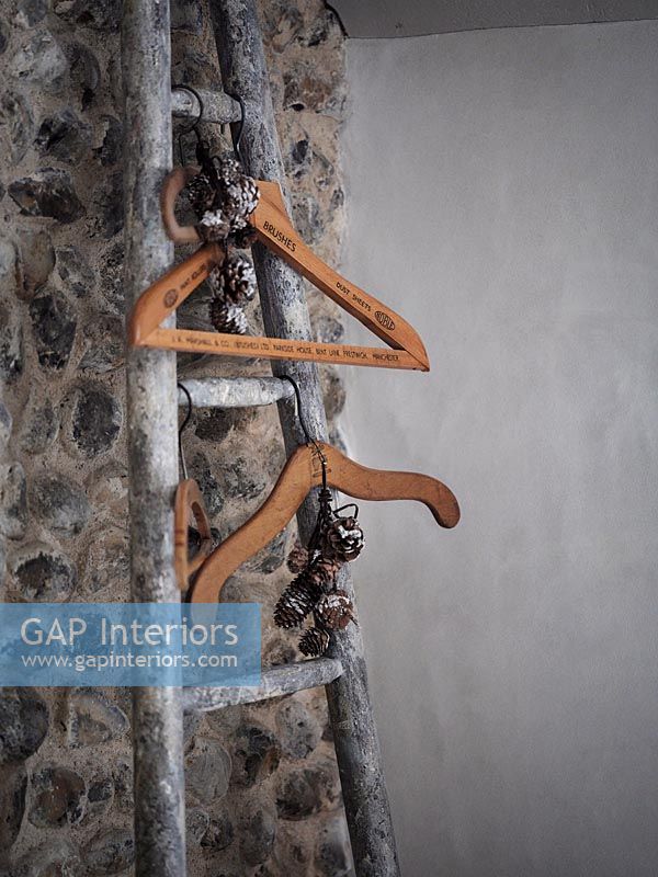 Detail of wooden clothes hangers on rustic ladder 