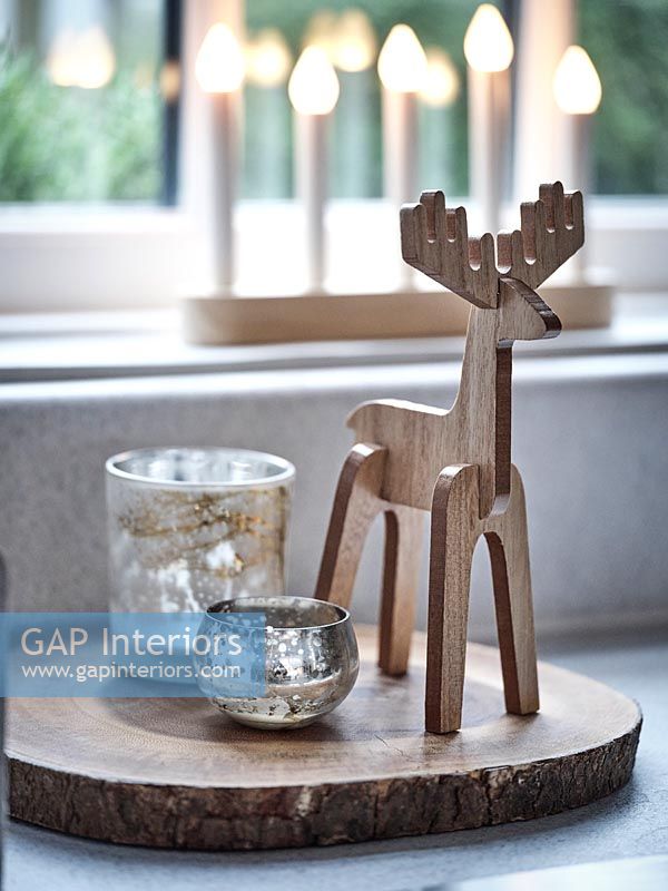 Carved wooden reindeer next to tealight holders - detail 