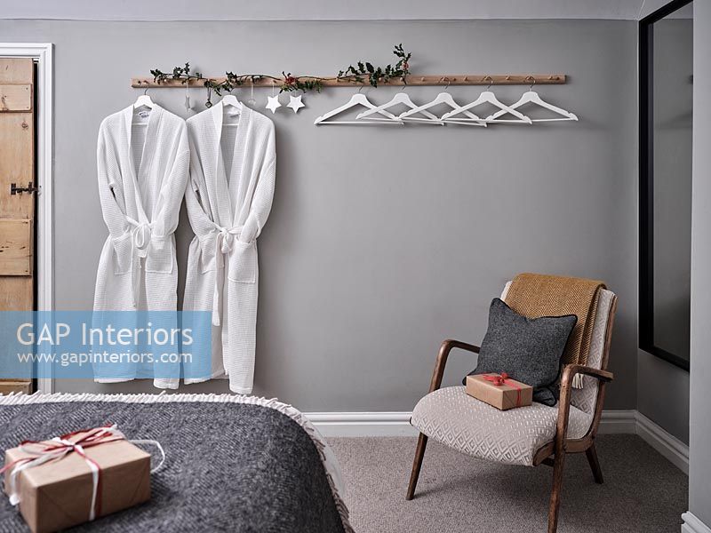 Matching dressing gowns on coat hooks in modern bedroom at Christmas time 