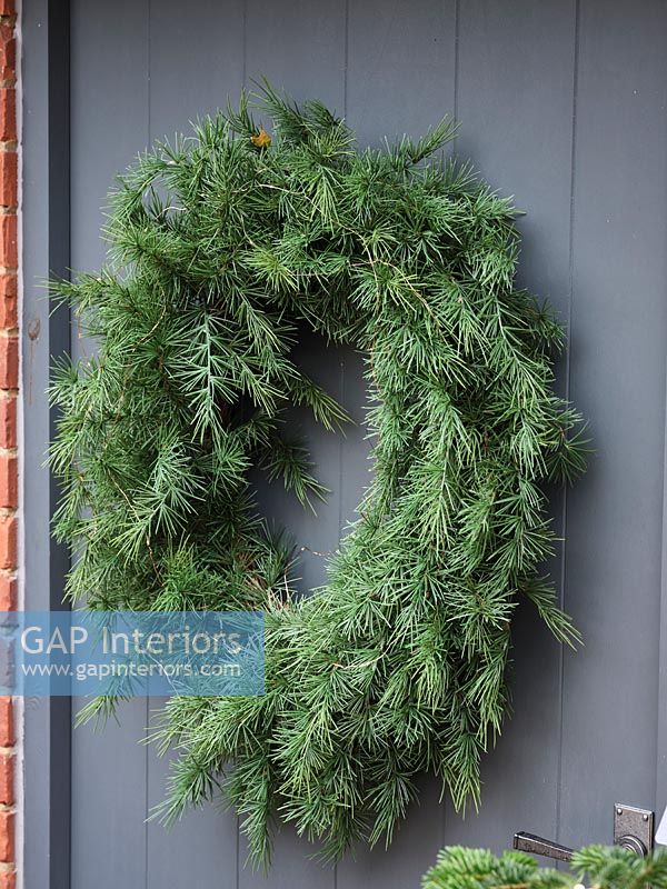 Large green wreath on front door of country house