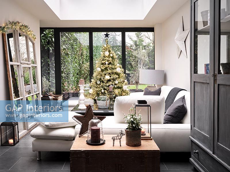 Christmas tree next to patio doors in modern living room 