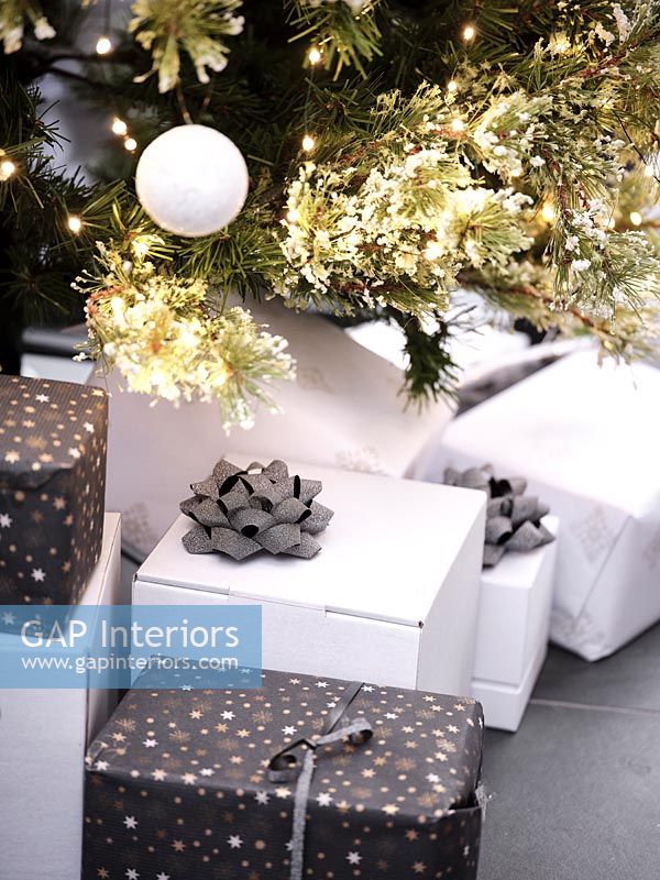 Black and white Christmas gifts in basket under tree 