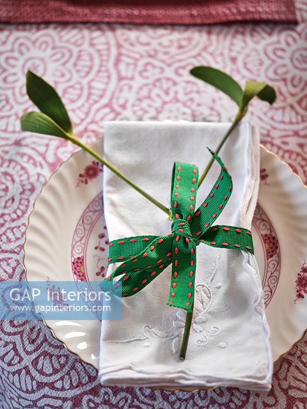Decorative mistletoe and ribbon on serviette