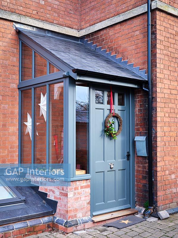 Christmas wreath on grey painted front door exterior 