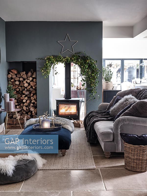 Modern living room with lit wood burner decorated for Christmas 