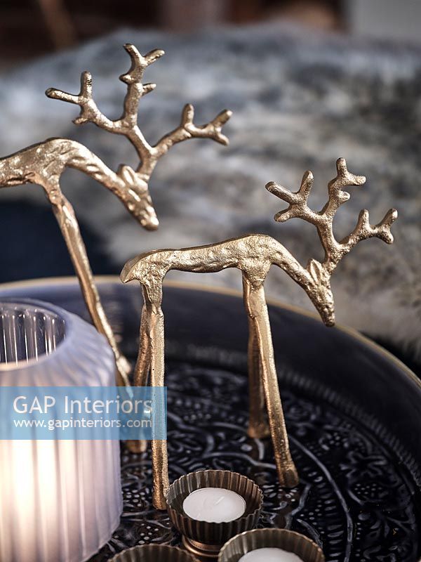 Gold reindeer Christmas ornaments and tealight candles 