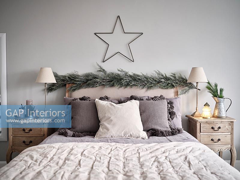 Garland and star above headboard in modern bedroom 