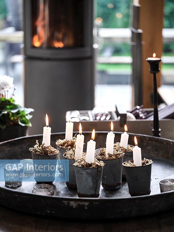 Lit candles in tiny pots on metal tray 