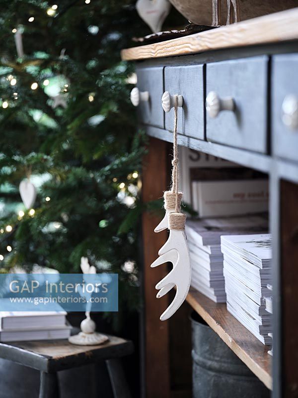 White antler ornaments hanging from sideboard drawer 