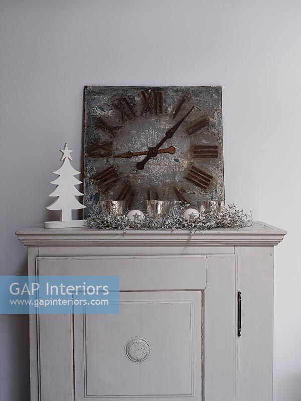 Clock on small cabinet with Christmas decorations 
