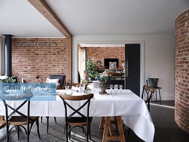 Table cloth on dining table in modern dining room with exposed brickwork 