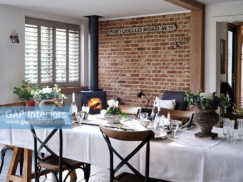 Tablecloth on dining table in modern dining room with exposed brickwork 