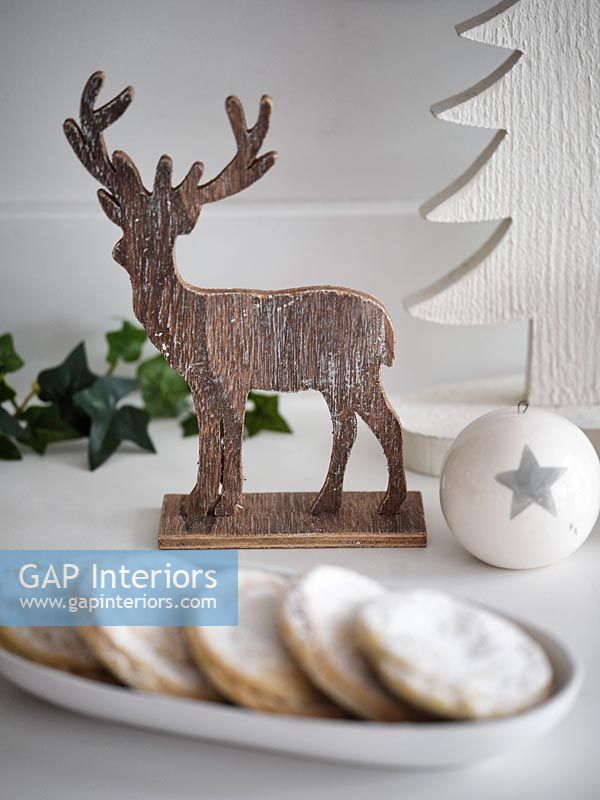 Carved reindeer Christmas ornament and mince pies 