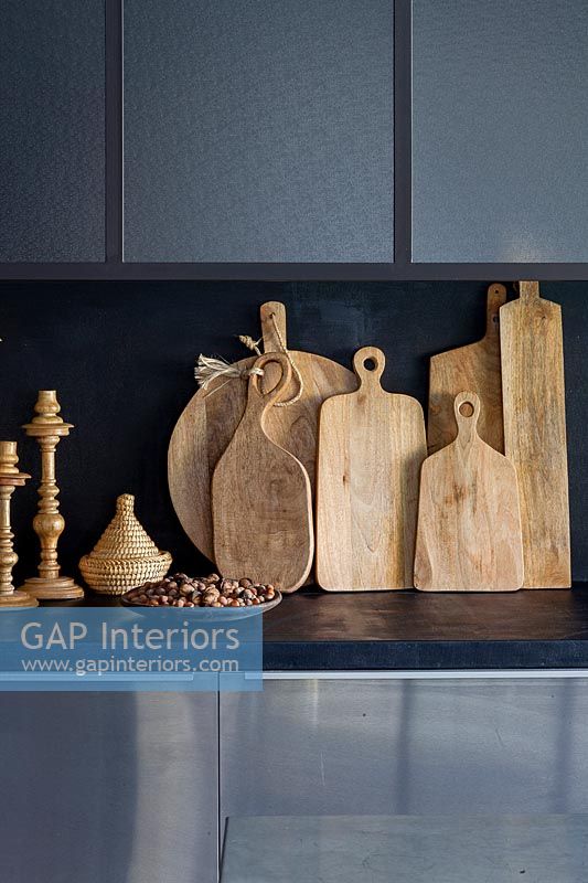 Collection of wooden chopping boards on modern kitchen worktop 