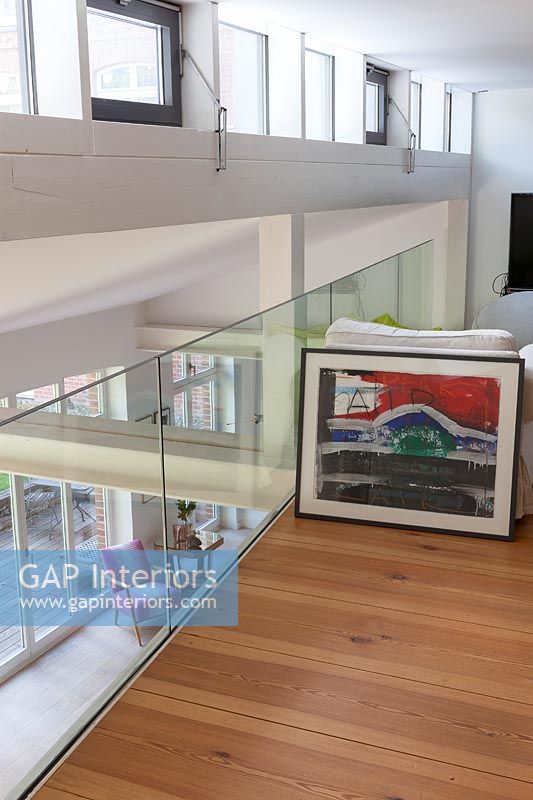 Colourful framed painting on modern upstairs landing 