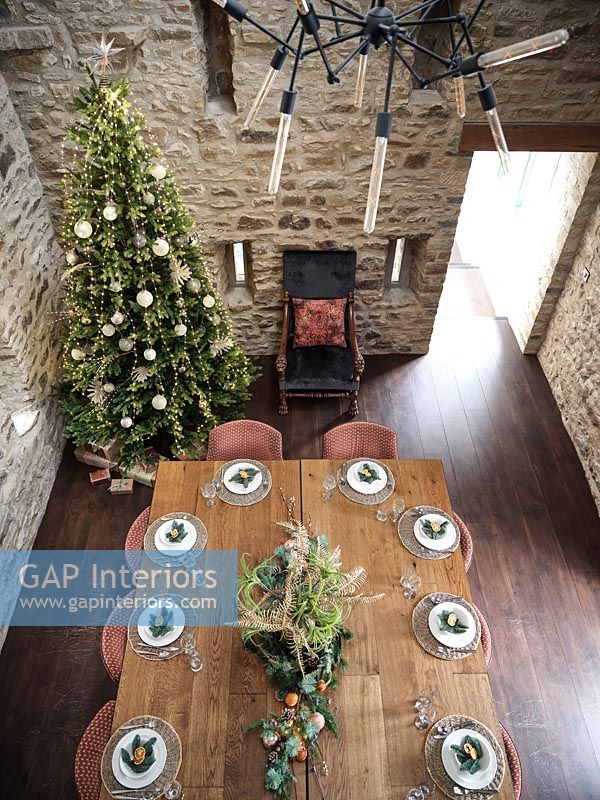 Overhead view of wooden dining table laid for Christmas dinner 