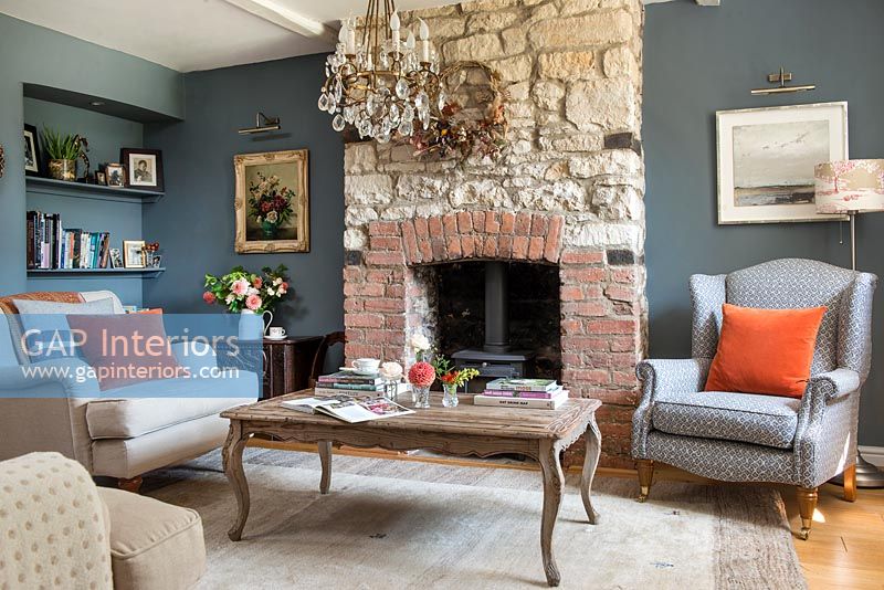 Country living room with exposed stone chimney breast 