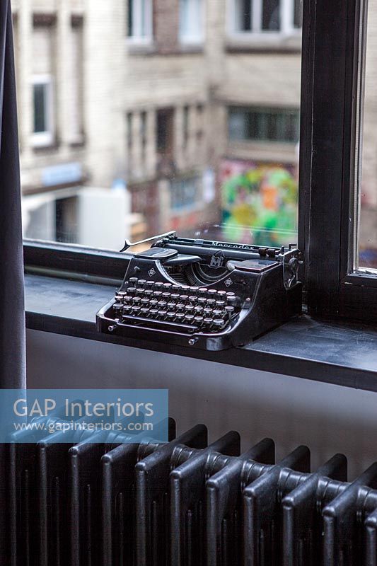 Vintage typewriter on windowsill 