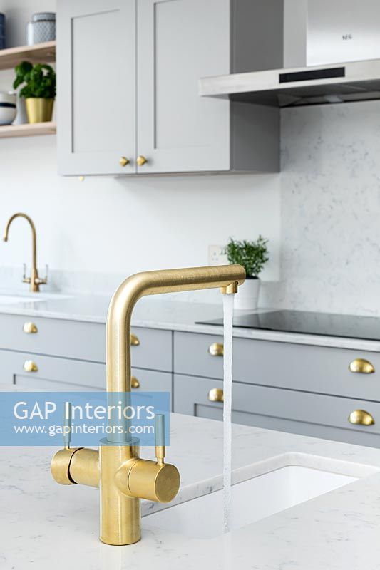 Modern kitchen sink with gold running tap