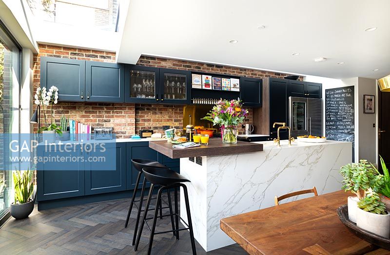 Modern kitchen with dark grey painted units and a white marble island