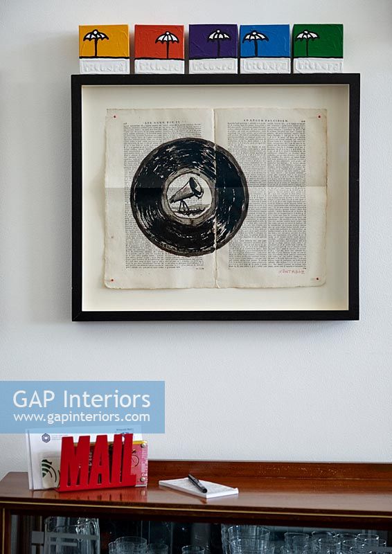 Vintage music artwork hanging on wall above letter holder on table