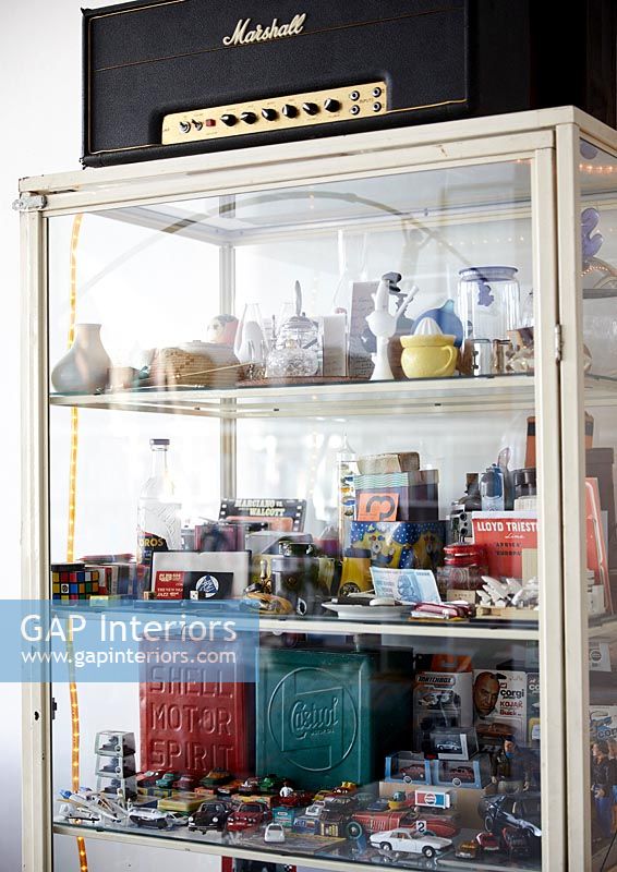 Glass fronted display cabinet full of vintage toys and bric-a-brac