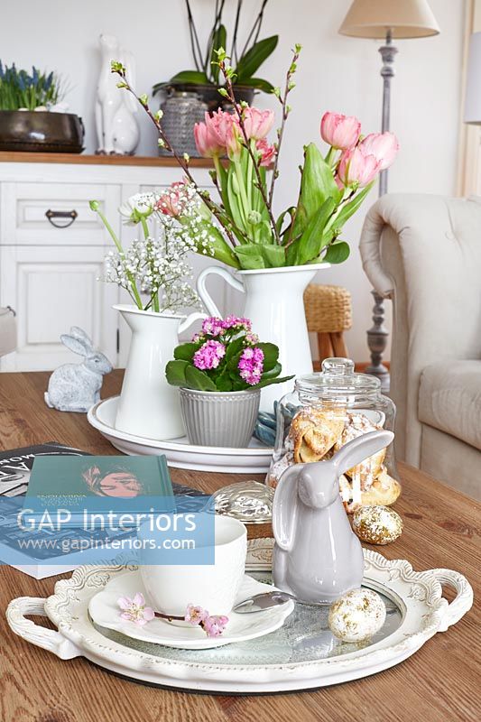 Spring flowers and Easter ornaments on coffee table 