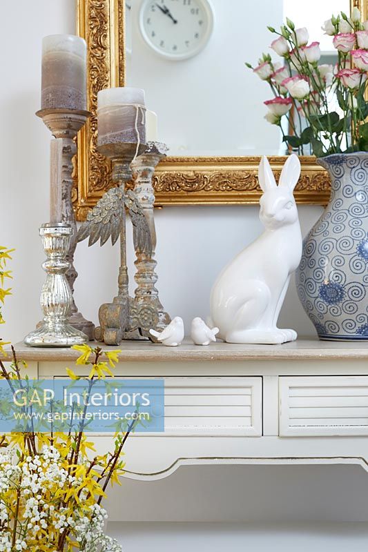 Easter decorations and spring flowers on console table 