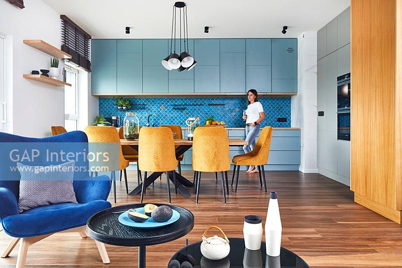 Brightly coloured open plan apartment with middle eastern influence with woman in kitchen area