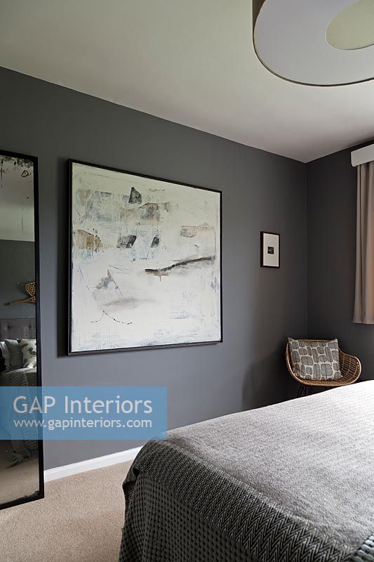 Large artwork in grey painted wall in modern bedroom 