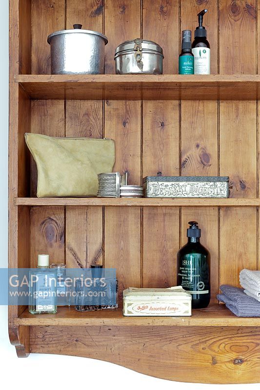 Toiletries and accessories on wooden bathroom shelves - detail 