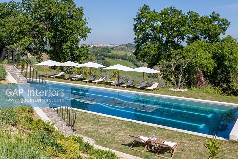 Swimming pool with loungers and scenic views of landscape beyond 