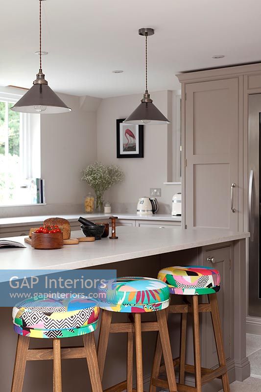 Colourful barstools in neutrally painted modern kitchen 