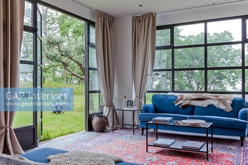 Modern living room with open patio doors to garden 