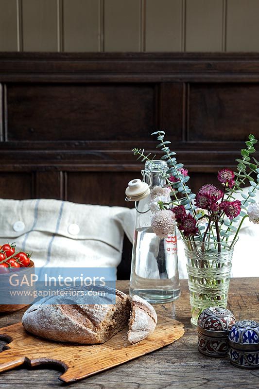 Fresh bread displayed on dining table with vase of flowers