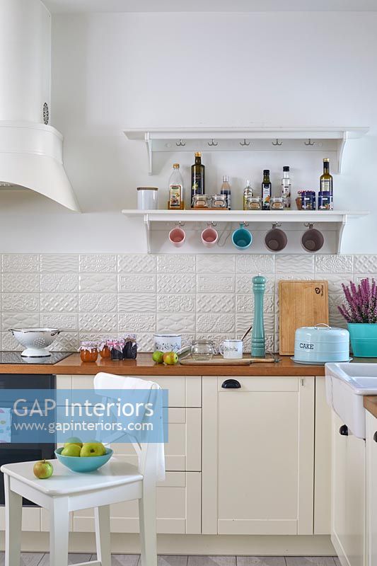 Modern cream and white kitchen with turquoise accessories 