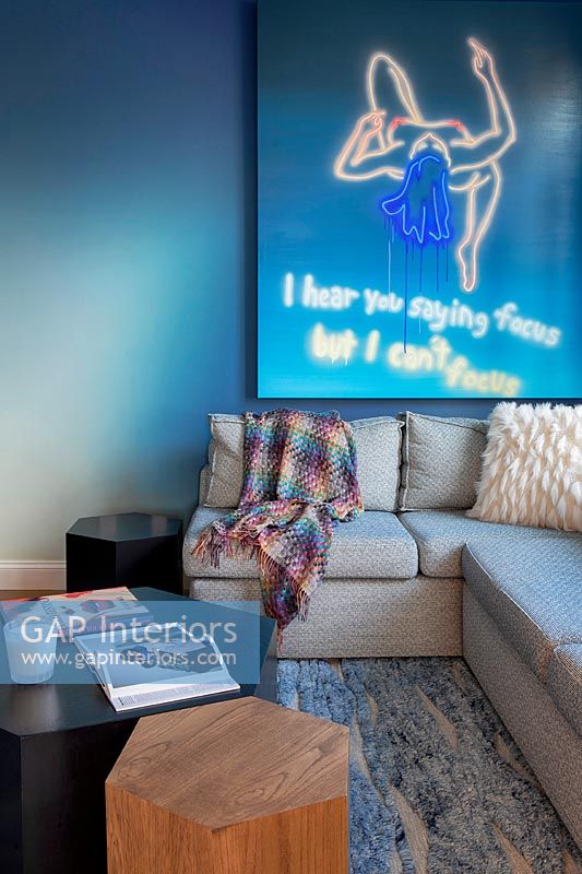 Modern artwork on blue living room wall 