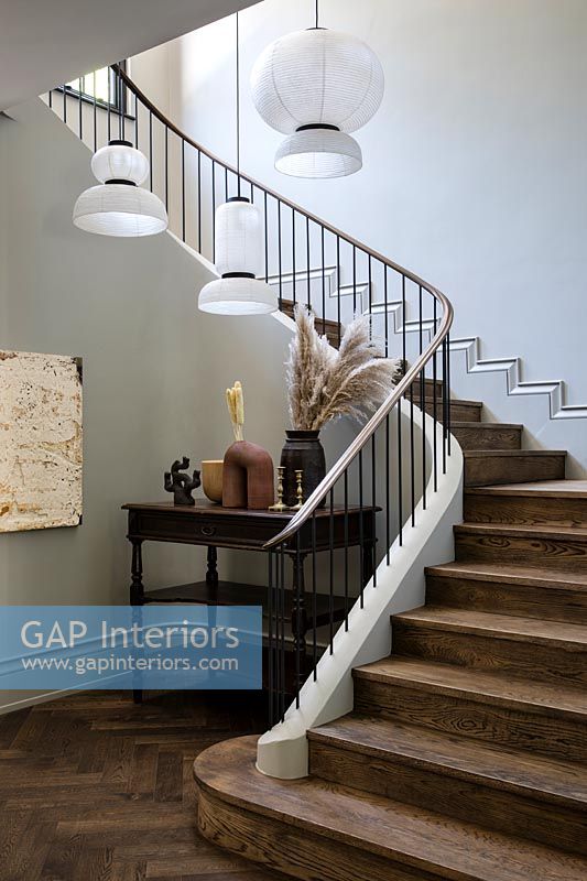 Modern pendant lights over classic staircase 