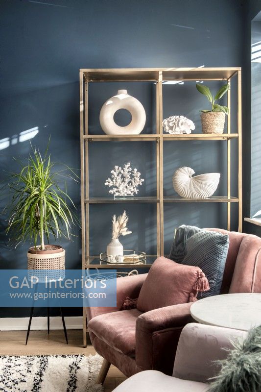 Gold shelving with display of white objects against dark wall