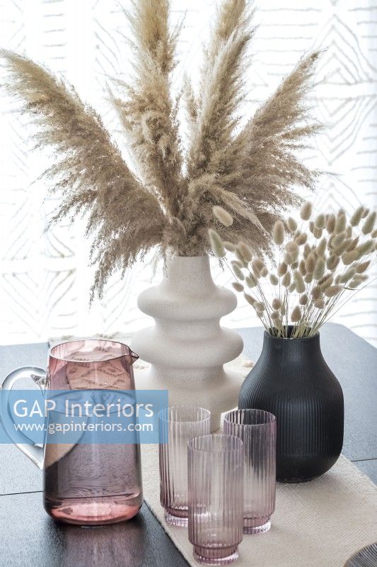 Detail of dried grasses in vases on modern dining table