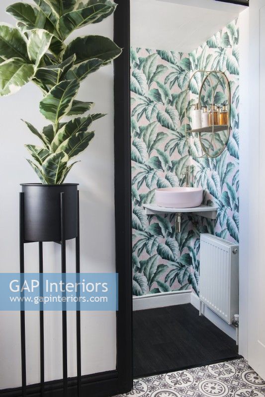 View into modern bathroom with patterned wallpaper 
