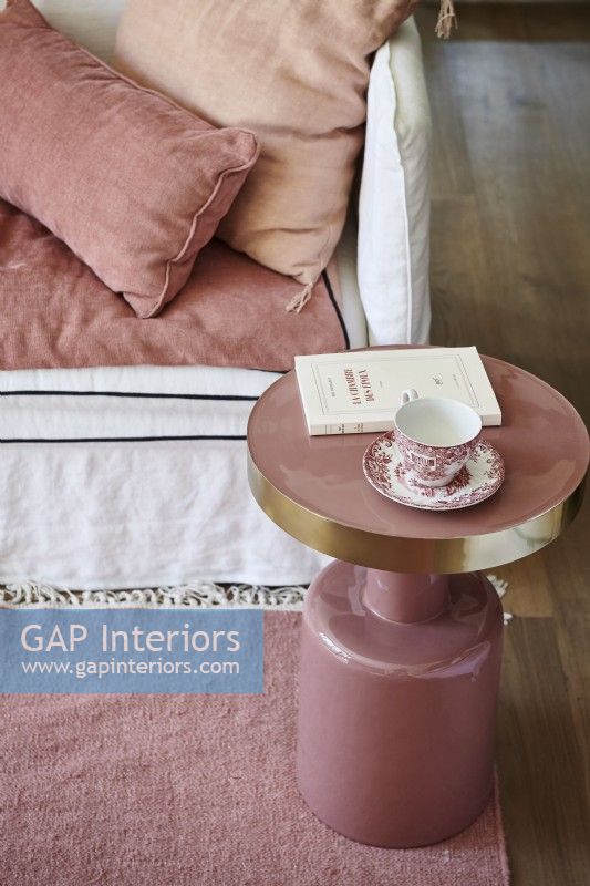 Detail of small pink side table next to sofa 