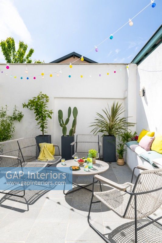 Furniture in sunny walled courtyard garden